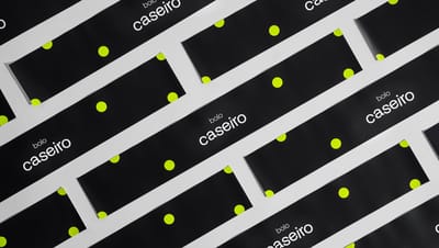 Diversas cintas para bolo com design moderno e estampa de bolinhas verdes sobre fundo preto, organizadas em folhas para aplicação em embalagens de bolos caseiros.