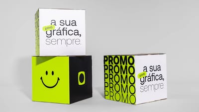 Dois cubos montados um em cima do outro e outro cubo montado e posicionado ao lado dos dois, com design promocional vibrante, estampados com frase dizendo "printi, a sua gráfica, sempre", logotipo da printi, smile e palavra 'PROMO'.