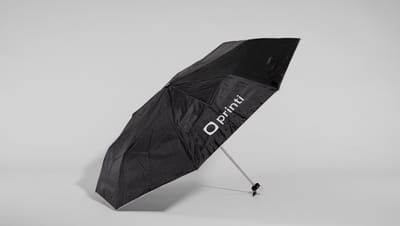 Guarda-chuva dobrável aberto na cor preta com a logo da Printi