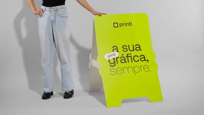 Pessoa segurando cavalete personalizado verde com logo e slogam da Printi.