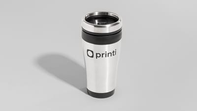Copo térmico de inox posicionado em pé sobre superfície cinza neutra, com logotipo da Printi em destaque e tampa com bico dosador