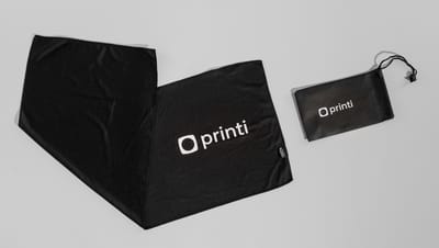 Toalha esportiva em PET com bolsa, ambas na cor preta com logo da Printi.
