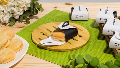 Mesa com várias caixinhas para bem casado personalizadas nas cores branco e preto.