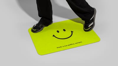 Pessoa pisando em Capacho personalizado na cor verde com slogam da Printi e Smile.