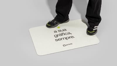 Pessoa pisando em tapete personalizado da Printi com a frase “a sua gráfica, sempre”
