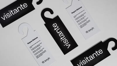 Vários modelos de Display Retrovisor com design preto e branco e informações para visitantes, dispostos em padrão sobre fundo cinza claro.