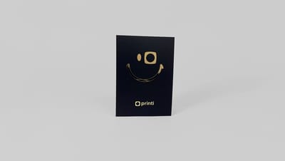Flyer personalizado azul-marinho com acabamento dourado metalizado e logo impresso, exibido em mockup minimalista.