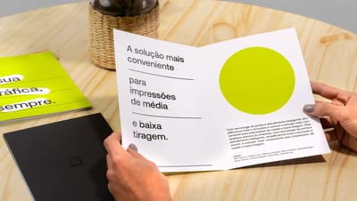 Pessoa segurando folder 1 dobra em verniz aberto.