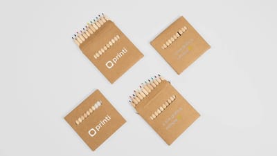 Lápis de cor personalizados organizados em embalagem kraft com slogan e logomarca da Printi.
