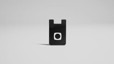 Porta Cartões para Celular em Silicone na cor preta com logotipo branco centralizado, em fundo neutro para destaque do produto