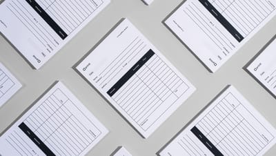 Diversos modelos de recibo organizados em padrão geométrico sobre superfície cinza, destacando o layout limpo e profissional com áreas específicas para dados do cliente, produtos, preços e assinaturas