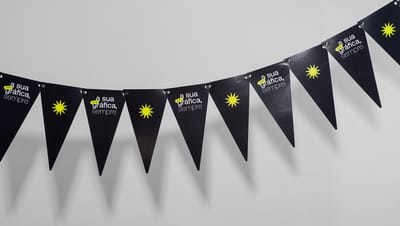 Cordão com várias bandeirolas pretas personalizadas com a frase 'printi, a sua gráfica sempre' e ícone gráfico amarelo