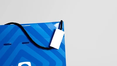 Sacola personalizada com acabamento premium em verniz UV e logotipo institucional em fundo azul.