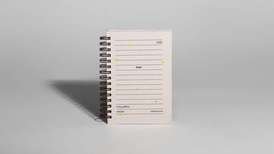 Agenda personalizada com capa em papel reciclado e espiral metálico para o ano de 2026.