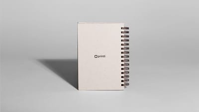 Agenda personalizada com capa minimalista e encadernação em espiral, ideal para organização diária e brindes corporativos.