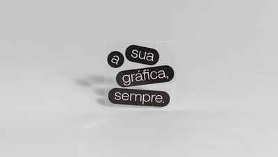 Adesivo transparente personalizado com a frase "A sua gráfica, sempre" em preto e branco, ideal para vitrines e embalagens.