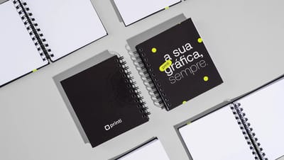 Caderno pequeno personalizado da Printi com capa dura impressa em design moderno. A imagem destaca o acabamento em espiral wire-o preto e a nitidez da impressão personalizada, ideal para brindes corporativos.