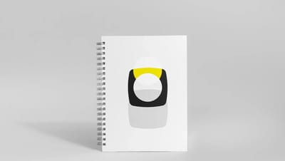 Capa de caderno personalizado com design minimalista em branco e preto com detalhes em amarelo, exibindo acabamento premium e espiral metálico.