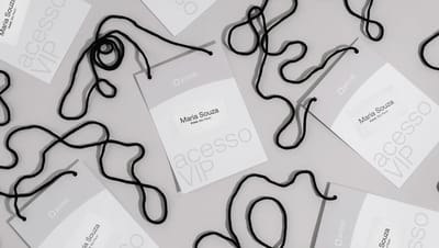 Vista superior de várias credenciais de identificação personalizadas espalhadas com cordões pretos. Os crachás de acesso VIP exibem o logotipo da Printi e o nome impresso "Maria Souza".