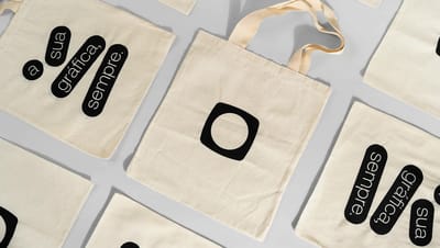 Conjunto de ecobags de algodão cru personalizadas com diferentes layouts de impressão, demonstrando a qualidade gráfica e versatilidade para brindes corporativos.