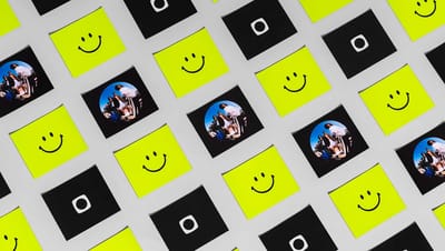 Vários modelos de ímã de geladeira quadrado espalhados, alternando entre estampas de emoji de carinha sorridente amarela, fotos de pessoas e um logotipo branco em fundo preto.