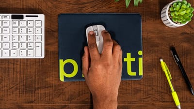 Mouse pad redondo personalizado da Printi em verde neon com ícone de sorriso, posicionado em mesa de escritório moderna.