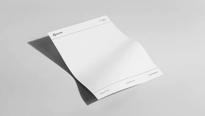 Papel timbrado personalizado da marca Printi em um mockup elegante sobre fundo cinza, exibindo logotipo, site e informações de contato.