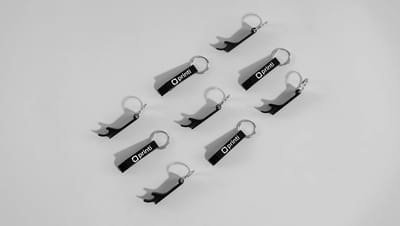 Conjunto de chaveiros abridores de garrafa em metal preto com logotipo da Printi.