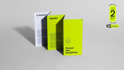 Folder 4 dobras em pé com dobra estilo sanfona, destacando a capa verde com o logo do Parque das Laranjeiras e as páginas internas brancas. Imagem de estúdio com selo promocional de frete e entrega rápida em 2 dias.