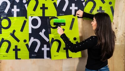 Aplicação de lambe-lambe personalizado em parede de madeira com cores preto e verde neon vibrantes.
