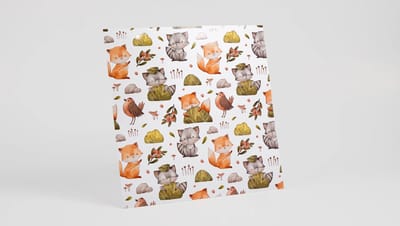 Papel Scrapbook com estampa repetida de raposas, guaxinins e elementos da natureza em tons terrosos e estilo aquarela.