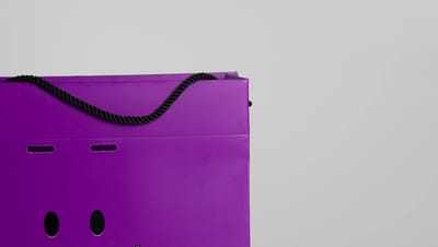 Sacola de papel personalizada na cor roxa com alça de corda para embalagem de produtos.
